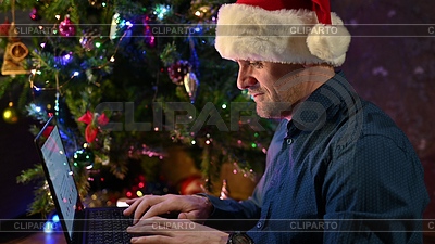 Hombre feliz que llama a amigos para la Navidad usando la computadora portátil | Foto de alta resolución |ID 7390229