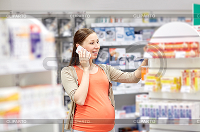 Mujer embarazada feliz con el teléfono inteligente en la farmacia | Foto de alta resolución |ID 5493145