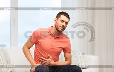 Unhappy man suffering of stomach ache at home | High resolution stock photo |ID 5580243